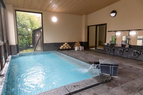 a large swimming pool in a large room at 静かなお宿加賀美 in Shimojo mura