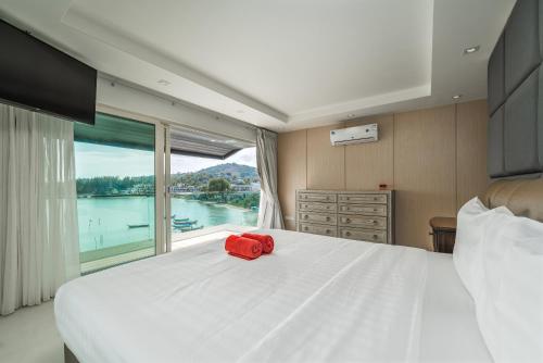 1 dormitorio con 1 cama blanca grande y ventana grande en 4-Storey, 3BR Seaview Villa Jayden, en Panwa Beach