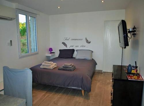 a bedroom with a bed with towels on it at gîte de Codeval in Fronton