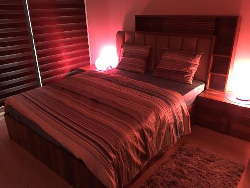 czerwona sypialnia z dużym łóżkiem z dwoma lampami w obiekcie Atasehir rezidans kendi eviniz gibi rahat w Stambule