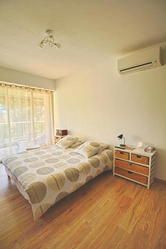 une chambre avec un lit et une table avec une lampe dans l'établissement Appartement Le Kent centre ville AJACCIO, à Ajaccio