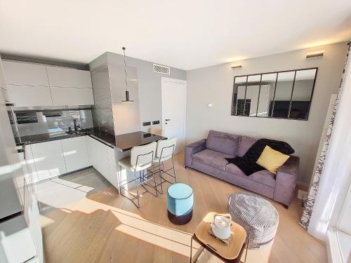 Il comprend un salon avec un canapé violet et une cuisine. dans l'établissement Nestor&Jeeves -PERLE DOREE - Terrace - Design, à Nice