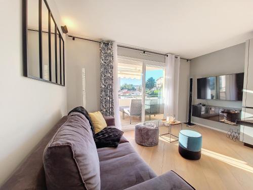 un salon avec un canapé et une grande fenêtre dans l'établissement Nestor&Jeeves -PERLE DOREE - Terrace - Design, à Nice