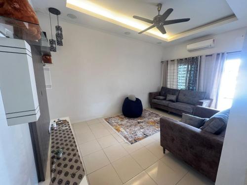 een woonkamer met een bank en een plafondventilator bij Home Sweet Home in Seremban