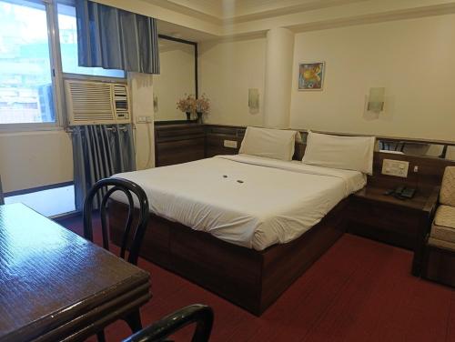 a bedroom with a bed and a table and a chair at Hotel Panorama Resorts in Mahabaleshwar