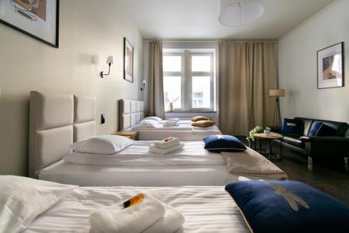 een hotelkamer met 2 bedden en een bank bij Apartments Wróblewskiego Street in Krakau