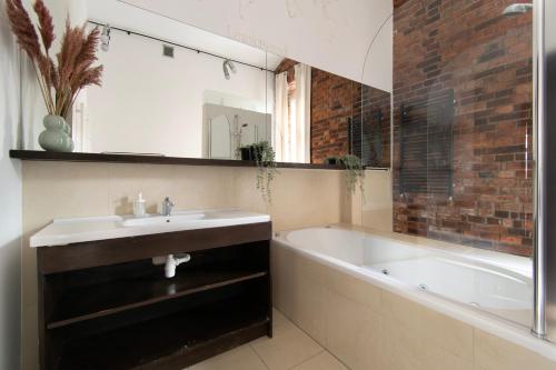 een badkamer met een wastafel en een bad bij Apartments Wróblewskiego Street in Krakau