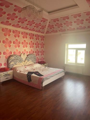 - une chambre avec un lit orné de fleurs roses sur le mur dans l'établissement Luxury villa by the sea, à Baku