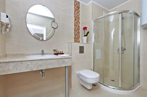 y baño con aseo, lavabo y ducha. en Private Apartments in White Rock Castle en Balchik