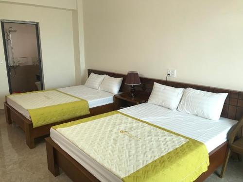 1 dormitorio con 2 camas y espejo en Khách sạn Sơn Hiền Cửa Lò, en Cửa Lô