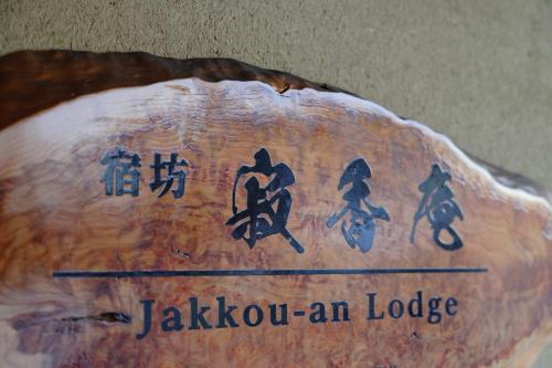 un cartel que dice jakoxin un lodge en un tronco en 一棟貸しの宿 寂香庵, en Kamakura