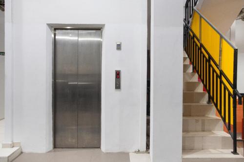 a metal elevator in a building with stairs at Kost K23 in Surabaya