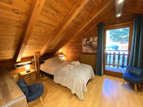 una camera da letto con un letto e una grande finestra di LE RENNE Chalet en bois au calme avec SPA Jacuzzi a La Bresse