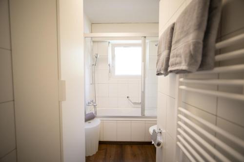 a bathroom with a shower and a bath tub at Brentschpark 33 in Scuol