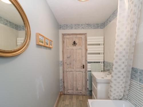 a bathroom with a toilet and a sink and a mirror at Shell Seeker Cottage in Bridlington