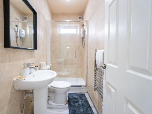 a bathroom with a sink and a toilet and a shower at Cohost Partners | Stylish and spacious 1Br in Newport