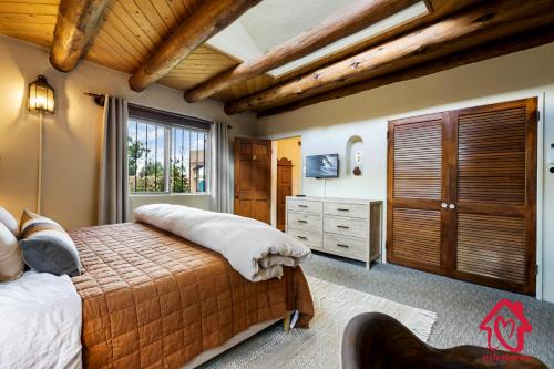 a bedroom with a bed and a dresser and a window at Rancho de La Luna Casita in Santa Fe