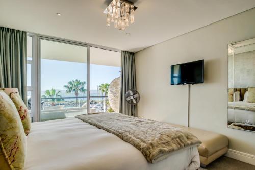 a bedroom with a large bed and a large window at Aqua Views in Cape Town