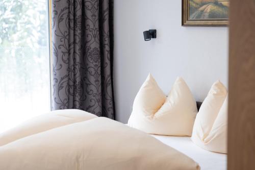 a bedroom with a bed with pillows and a window at Alpenhof Chalets in Gerlos
