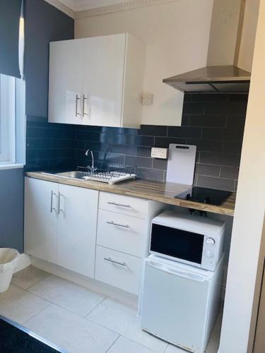 a kitchen with white cabinets and a sink at Circle Guest House Bed Only in Southampton