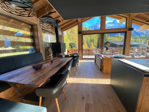 une cuisine avec une grande table en bois et une grande fenêtre dans l'établissement Chalet Aikoa, à Chamonix-Mont-Blanc