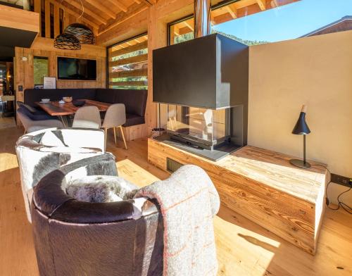 a living room with a tv and a fireplace at Chalet Aikoa in Chamonix