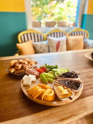 a plate of cheese and vegetables on a wooden table at Cabbana Hotel Lara in Antalya