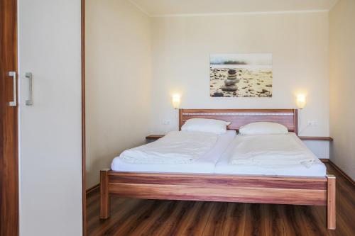 SahrensdorfにあるFerienhof Büdlfarm - Westのベッドルーム1室(白いシーツと枕のベッド1台付)