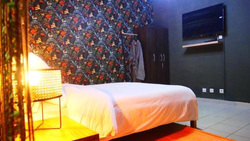 a bedroom with a bed with a floral wall at Résidence Tropicale in Libreville