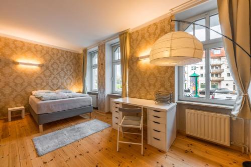 a bedroom with a desk and a bed and windows at Exklusive und großzügige Wohnung 140 qm in Magdeburg TOP-Lage mit Kicker für bis zu 8 Personen in Magdeburg