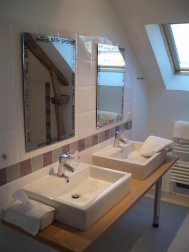une salle de bain avec deux lavabos et deux miroirs dans l'établissement Les Chaufourniers / L'Ecurie, à Crouay