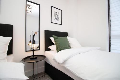 a bedroom with a white bed and a mirror at Central Charming and Contemporary 2Br Apartment in Swindon