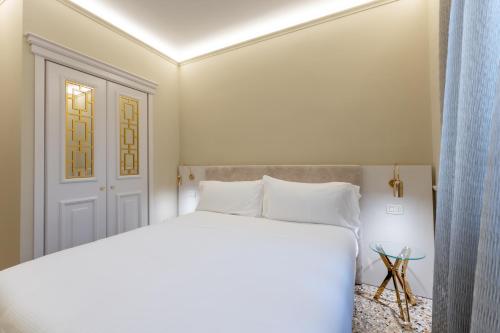 a bedroom with a white bed and a door at San Vio Palace Luxury Apartments in Venice