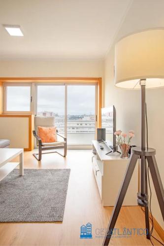 a living room with a lamp and a desk with a couch at Gaia Panoramic Terrace Apartment - D. Pedro V in Vila Nova de Gaia