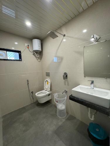 ein Badezimmer mit einem Waschbecken, einem WC und einem Spiegel in der Unterkunft Florence Continental Udaipur in Udaipur