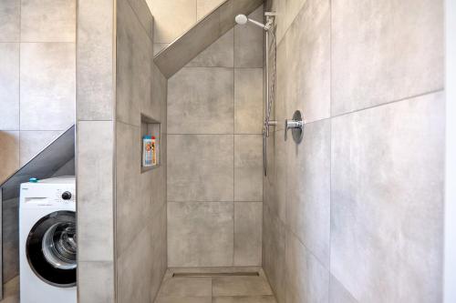 eine Duschkabine im Bad mit einer Waschmaschine in der Unterkunft Neubau Ferienwohnung mit Balkon in Gronau