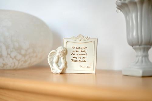 a small angel figurine sitting on a table with a picture at Neubau Ferienwohnung mit Balkon in Gronau