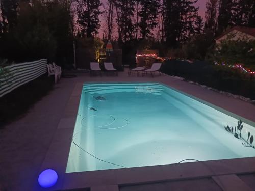 une piscine éclairée la nuit dans l'établissement Gite ALPILLES & piscine - Oliveraie Bio Mas de Cargane, à Entressen