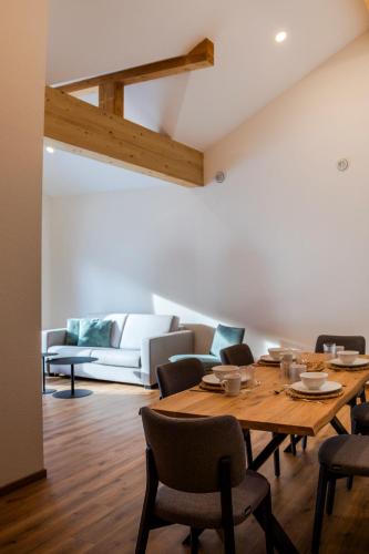 a dining room with a table and chairs and a couch at Das Steinach in Pfronten