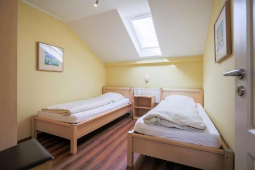 two beds in a room with a skylight at Ferienhof Büdlfarm - Nord in Sahrensdorf