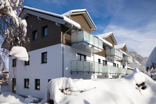 a building covered in snow in front of a mountain at Das Steinach in Pfronten