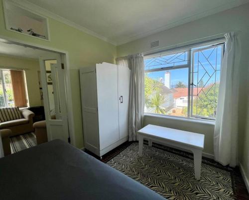 a bedroom with a bed and a large window at Harbour Cottage Kalk Bay in Cape Town