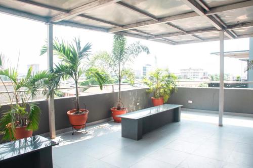 a balcony with potted plants and a bench in a building at willy's apartment in Lagos