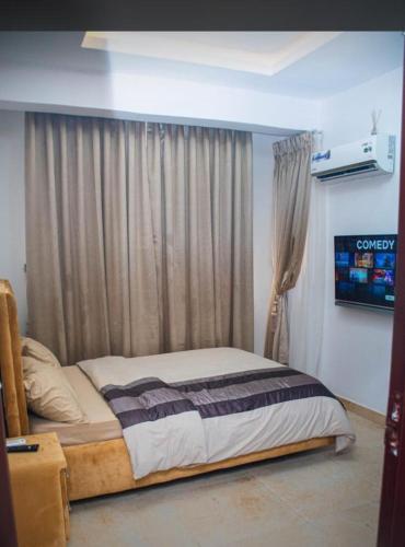 a bed sitting in a room with a window at willy's apartment in Lagos