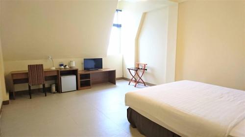 Un dormitorio con una cama y un escritorio con una computadora. en Polaris Hotel, en Kỳ Anh