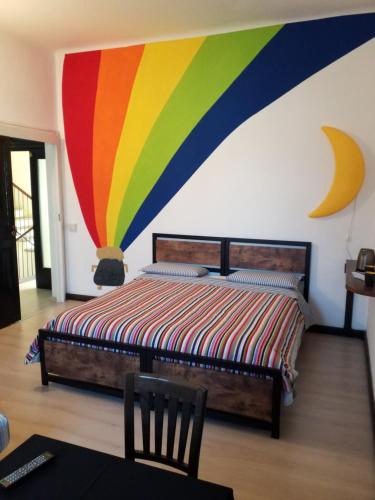 sypialnia z łóżkiem z kolorową ścianą w obiekcie Casa Nunzia w mieście Domodossola