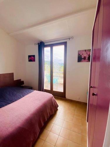 une chambre avec un lit et une grande fenêtre dans l'établissement Villa Bella Vista, Santa Giulia, à Porto-Vecchio