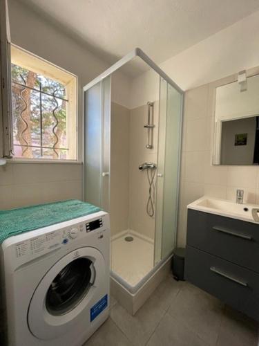 La salle de bains est pourvue d'un lave-linge et d'une douche. dans l'établissement Villa Bella Vista, Santa Giulia, à Porto-Vecchio