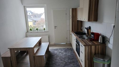 uma pequena cozinha com uma mesa e uma janela em Moderne Wohnung mit Gartenzugang em Essen