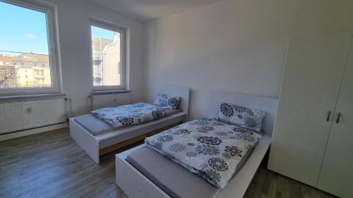 エッセンにあるModerne Wohnung mit Gartenzugangのベッドルーム1室(ベッド2台、窓2つ付)